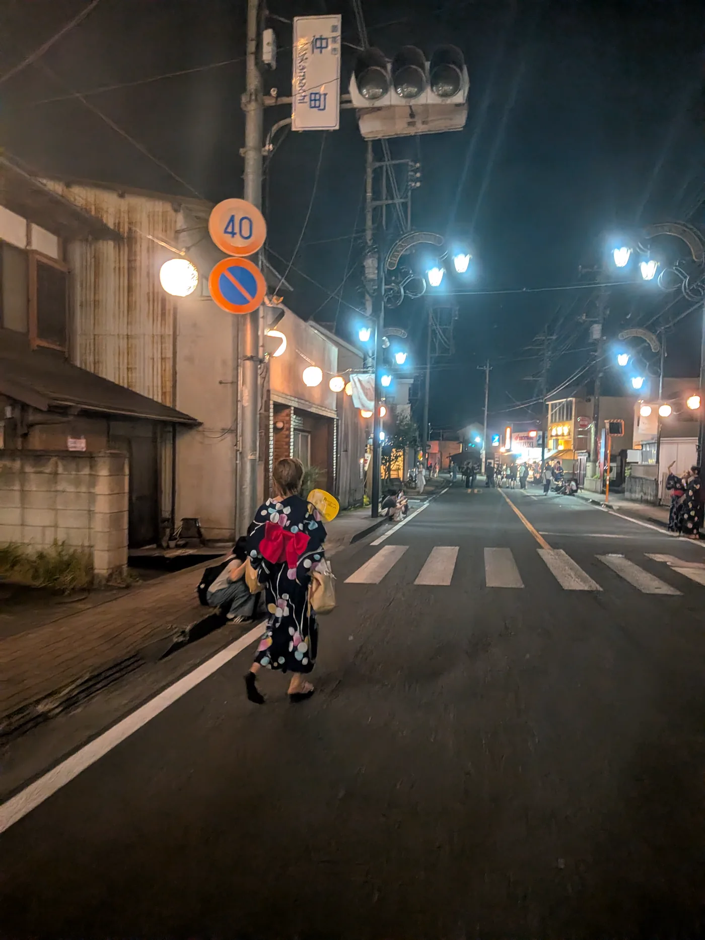 提灯の下を歩く後ろ姿の浴衣姿